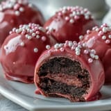 Easy Oreo Truffle Balls with Pink Candy Coating stacked on a white plate, ready to serve at a party.