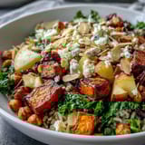 A Fall Harvest Bowl with toasted almonds, creamy feta, and crispy chickpeas next to crunchy celery pieces. 