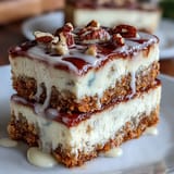 Carrot Cake Cheesecake Bars with creamy cheesecake swirls and a spiced carrot cake base, topped with smooth cream cheese frosting.