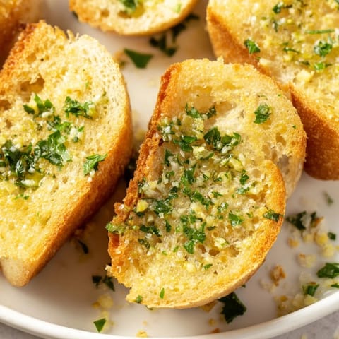 Homemade Garlic Bread with melted butter and fresh parsley, baked until perfectly crisp and ready for a family dinner.