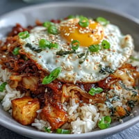 Vibrant Fermented Cabbage Kimchi Fried Rice Bowl, topped with a sunny-side-up egg.